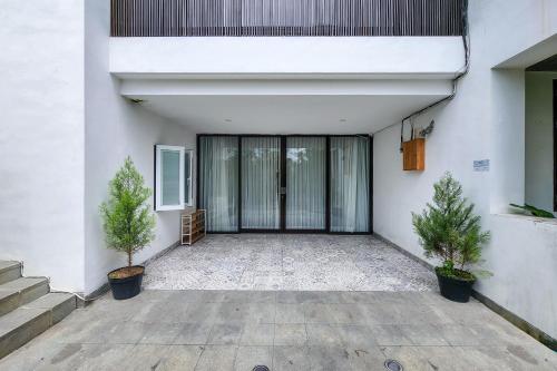 an empty courtyard with two potted trees in front of a building at Villa Emilia Seminyak by Nagisa Bali in Kerobokan