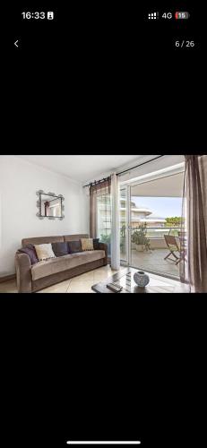 un salon avec un canapé et une grande fenêtre dans l'établissement Superbe appartement en front de plage, à Fréjus