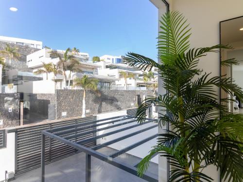 a balcony with a palm tree on a building at Serenity Casa Encanto in Adeje