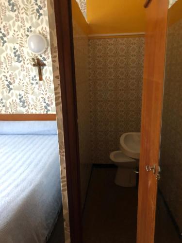 a small bathroom with a toilet and a sink at Hotel Villa Plaisance in Lourdes