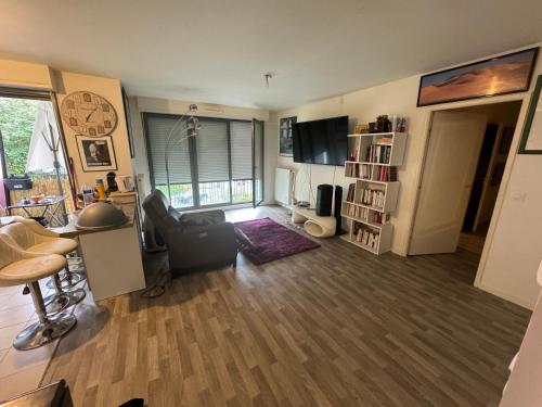 楠泰尔Jolie chambre à Nanterre Préfecture proche La Défense Aréna Campus SNCF et Paris的客厅配有桌子、椅子和桌子