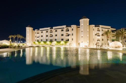 a building with a pool in front of it at night at Palma Hotel in Port Said
