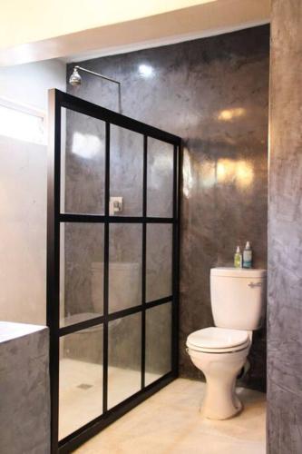 a bathroom with a toilet and a glass shower stall at Yours in Bloemfontein
