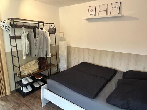 ein Schlafzimmer mit einem Bett und einem Kleiderständer in der Unterkunft Charmanter Rückzugsort Parkplatz Küche eigener Eingang in Nümbrecht