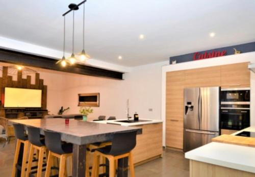 une cuisine avec une table avec des chaises et un réfrigérateur dans l'établissement Mas Manson, à Beaucaire