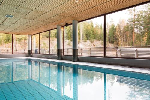 a swimming pool with a view of the trees at Hotel Korpilampi in Espoo
