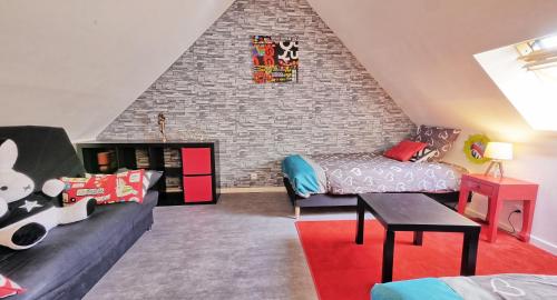 a attic room with a bed and a couch at A 2 pas d AZAY in Neuil