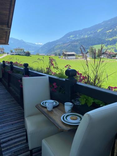 a table and chairs on a deck with a view of a field at Haus I'mperfect in Stumm