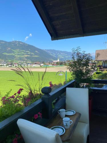 a table and chairs on a balcony with a view of a field at Haus I'mperfect in Stumm