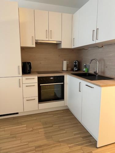 a kitchen with white cabinets and a sink at COHO City Apartments mit hauseigener Tiefgarage in Vienna