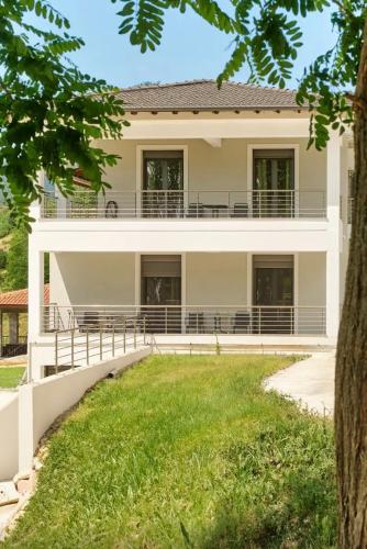 a house with a lawn in front of it at Δωμάτια Κωσταφάκας Κοκκινοπηλός Ολύμπου in Kokkinopilós