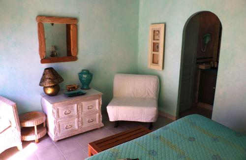 a bedroom with a dresser and a chair and a mirror at B&B Val D'azur in Carqueiranne