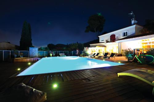 a large swimming pool in a yard at night at B&B Val D'azur in Carqueiranne