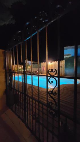 a view of a pool through a fence at night at Le N 9 in Argeliers