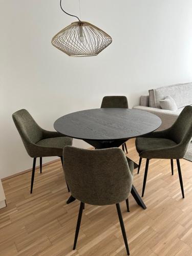 a dining room with a black table and chairs at COHO City Apartments mit hauseigener Tiefgarage in Vienna