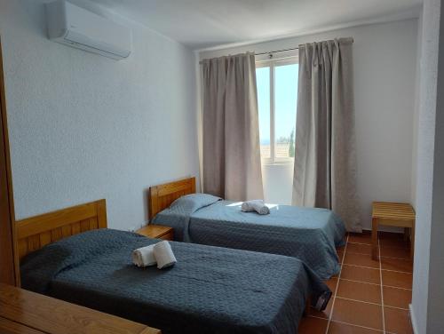 een hotelkamer met twee bedden en een raam bij Bay View Apartments in Albufeira