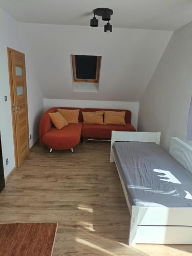 een woonkamer met een bank en een rode bank bij Apartament Przylesie in Stężyca