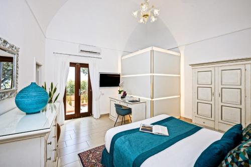 a bedroom with a bed and a desk and a table at Hotel Villa Gabrisa in Positano