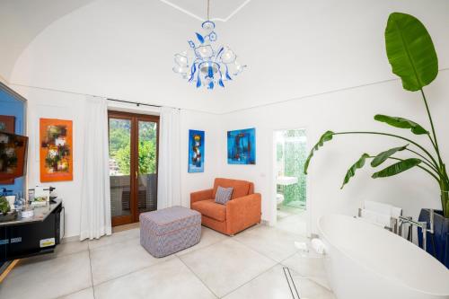 a living room with a chair and a chandelier at Hotel Villa Gabrisa in Positano