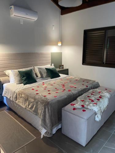 a bedroom with a large bed with red roses on it at Chalé rural- hospedagem e experiência! in Gaspar