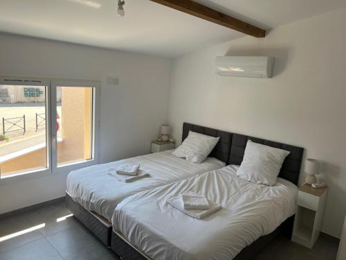 une chambre avec un lit avec deux serviettes dessus dans l'établissement Maison10 avec 1 chambre lechaffardcom, à Satolas-et-Bonce