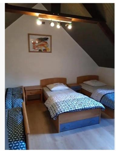 Cette chambre mansardée comprend 3 lits. dans l'établissement Maison 6 personnes en Bretagne, à Gicquel