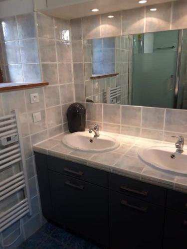 une salle de bain avec deux lavabos et un grand miroir dans l'établissement Maison 6 personnes en Bretagne, à Gicquel