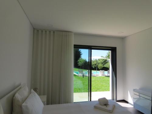 a bedroom with a bed and a large window at Basto Village House - Eco Smart Luxury Villa in Cabeceiras de Basto