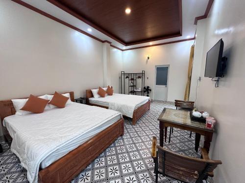 a hotel room with two beds and a tv at Homestay Mai Ngọc Tây Ninh in Tây Ninh
