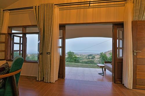 a living room with a large window and a couch at Lake George View Golf Resort in Kahendero