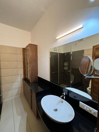 a bathroom with a sink and a mirror at Barefoot Homes, Varkala in Varkala