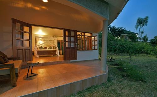 a house with a patio with a bed in the background at Lake George View Golf Resort in Kahendero