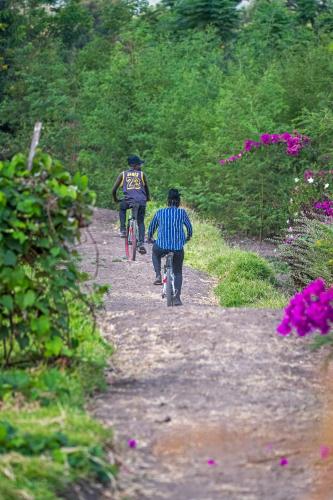 two people riding bikes on a dirt trail at Lake George View Golf Resort in Kahendero