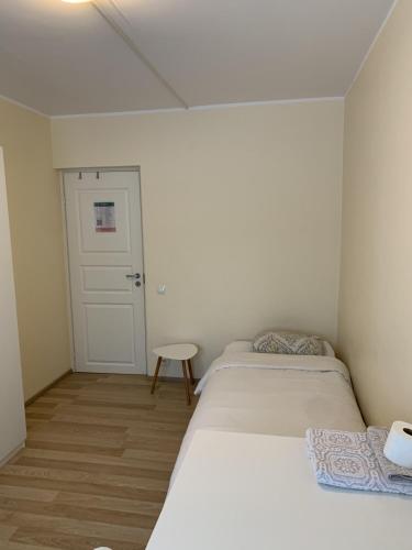 two beds in a small room with a door at Cozy Private Room by Tallinn Old Town in Tallinn
