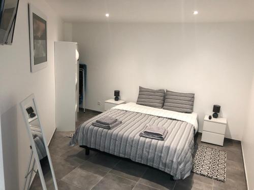 une chambre blanche avec un lit et deux tables de nuit dans l'établissement Appart Sara- Dieppe, L Escapade, à Neuville-lès-Dieppe