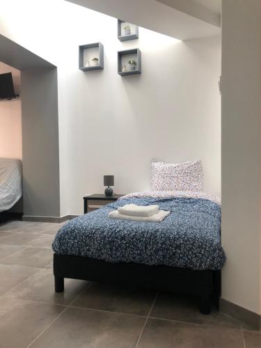 une chambre avec un lit avec une couette bleue dans l'établissement Appart Sara- Dieppe, L Escapade, à Neuville-lès-Dieppe