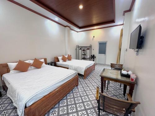 a hotel room with two beds and a tv at Homestay Mai Ngọc Tây Ninh in Tây Ninh