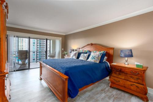 a bedroom with a bed with a blue comforter at Sand Key South Beach Condo #910 in Clearwater Beach