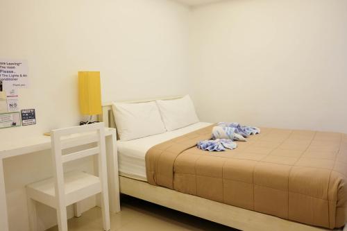 a bedroom with a bed with a desk and a chair at Baanpoon Apartment in Chaweng