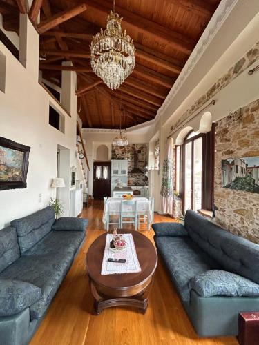 a living room with blue couches and a table at Αρχοντικό Γιούλη in Miléai