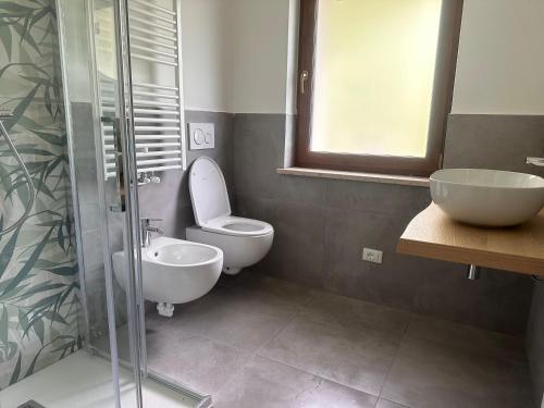 a bathroom with a toilet and a sink and a shower at Appartamenti Ai 7 nani in Peron