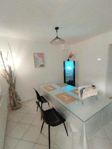 une salle à manger avec une table en verre et deux chaises dans l'établissement Chambre d'hôte, Entre les marais et la mer, à Wavrans-sur-lʼAa