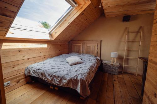 a bedroom with a bed in a room with a window at Les Gîtes de Sprimont - Le Cosy in Sprimont
