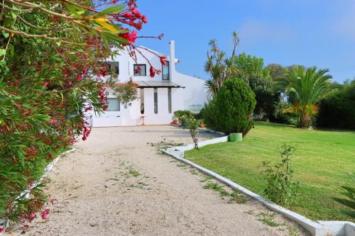 a house with a dirt road in front of a yard at Casa Seahorses b in Sintra