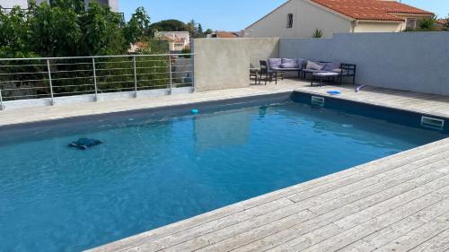 une piscine avec de l'eau bleue dans une cour arrière dans l'établissement Villa avec piscine, à Canet