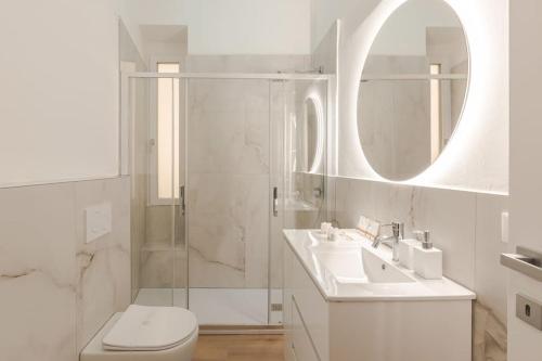 a white bathroom with a shower and a toilet and a sink at Luxury Apartment - 8 person - Centro Storico Trieste in Trieste