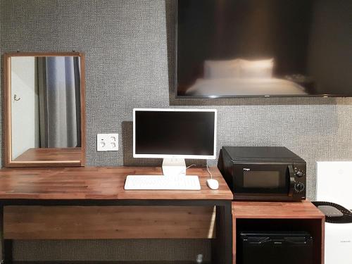 a desk with a computer and a printer and a monitor at Pension Inn in Geoje 