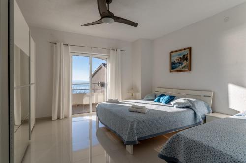 a bedroom with two beds and a view of the ocean at Vila Blanka in Podgora