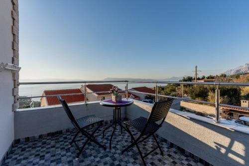 a balcony with a table and two chairs and a view at Vila Blanka in Podgora