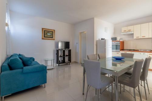 a living room with a table and a blue couch at Vila Blanka in Podgora